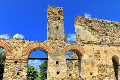 Low angle view of old ruins against blue sky