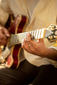 Midsection of man playing guitar