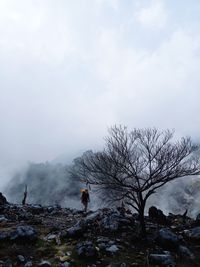 People standing on rock against sky