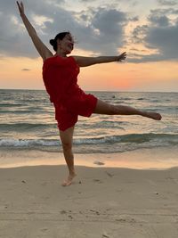 Full length of man on beach against sky during sunset