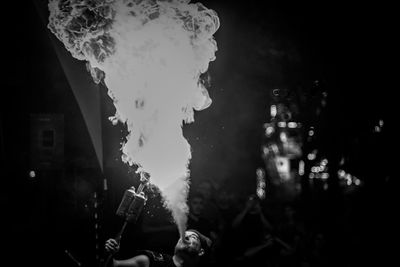 Panoramic shot of people holding cigarette at night