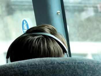 Rear view of man sitting by window