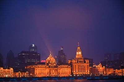 Illuminated buildings against sky at night