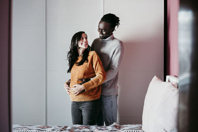 Rear view of couple standing against wall