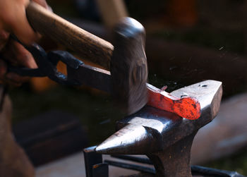 Blacksmith working on metal at forge