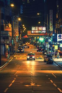 Vehicles on road in illuminated city at night