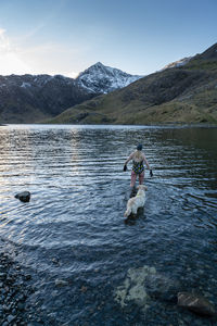 View of dog in lake against mountain range