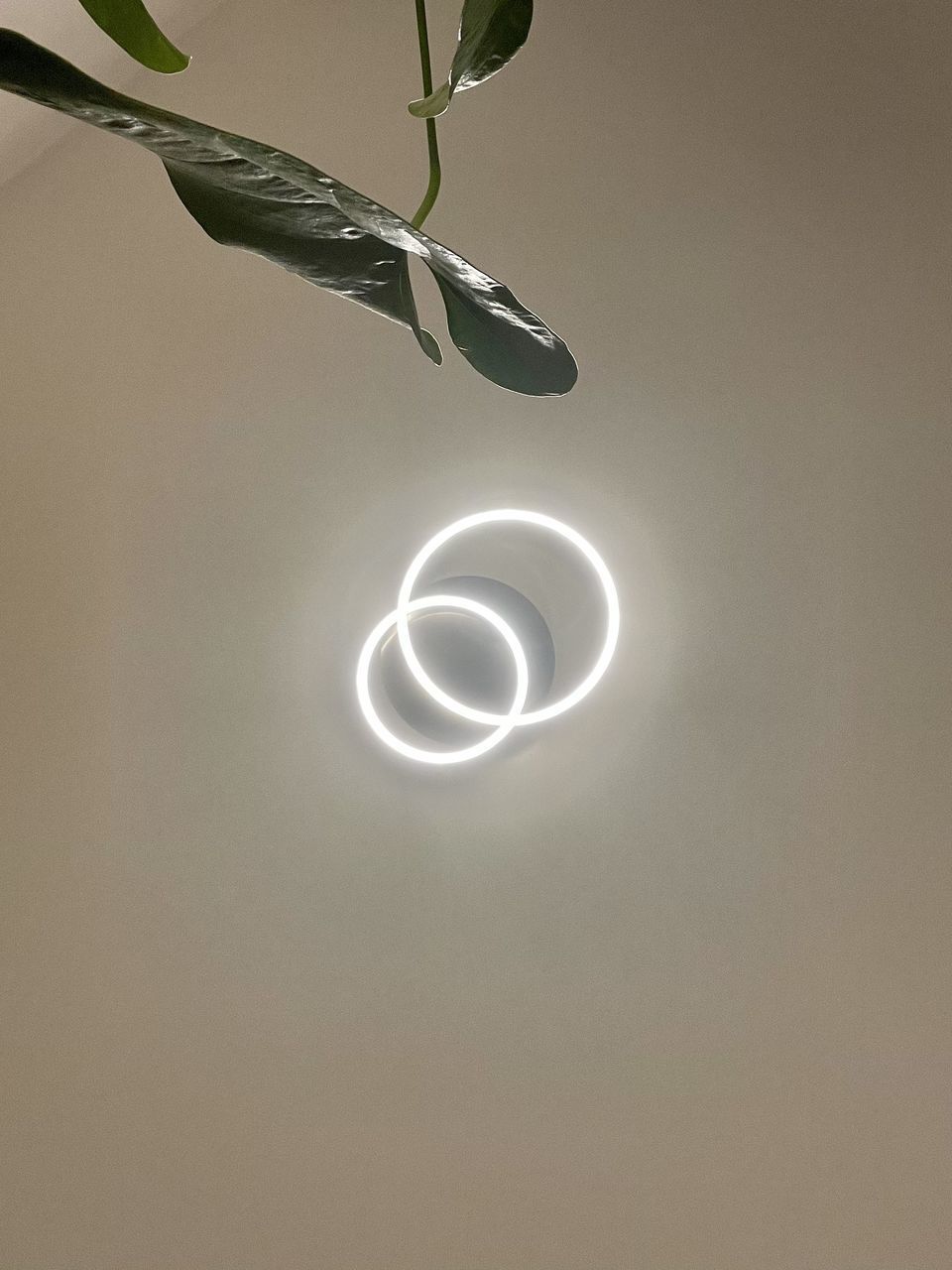 CLOSE-UP OF ILLUMINATED LIGHT BULB AGAINST CEILING