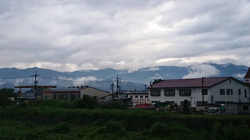 Houses by mountains against sky