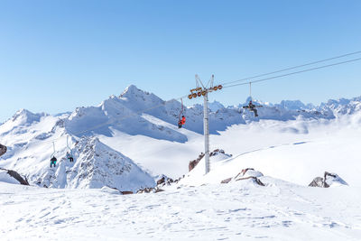 Scenic view of snow covered mountains against clear blue sky