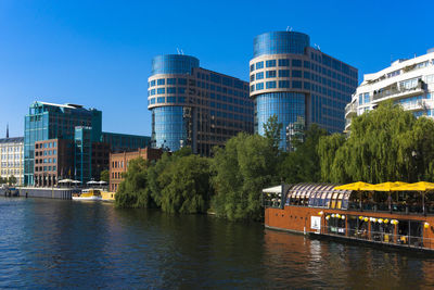 Bridge over river in city against clear sky