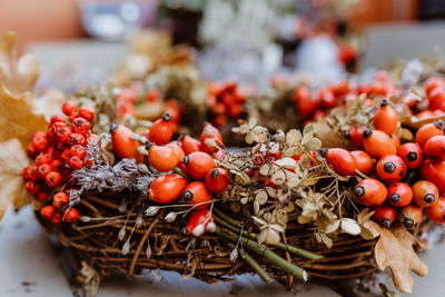 Handmade colorful floral autumn door wreath made of colorful rosehip berries, rowan, dry flowers 