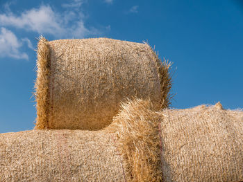 Hay bales on field against sky