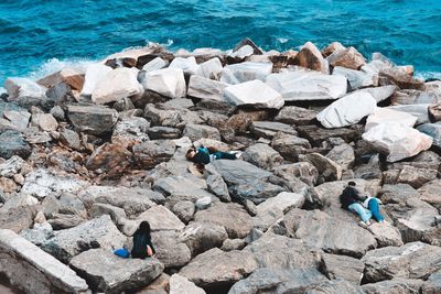 People standing on rocks at beach