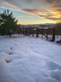 Scenic view of snow covered field against sky during sunset