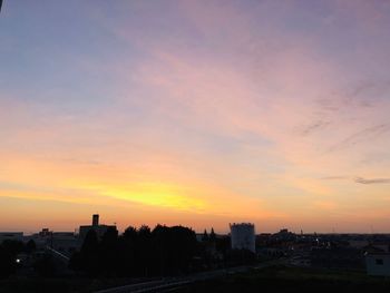 Silhouette buildings against sky during sunset