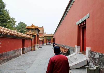 Rear view of man outside temple against building