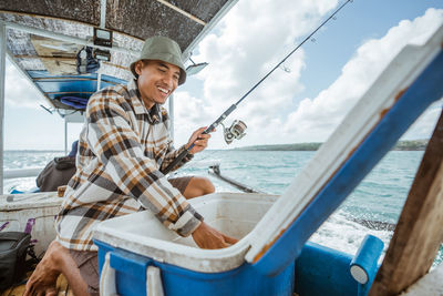 Portrait of young woman sitting on boat in sea