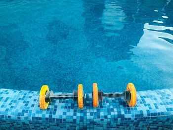 High angle view of dumbbells on swimming pool