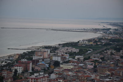 High angle view of townscape by sea against sky