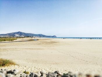 Scenic view of beach against clear blue sky