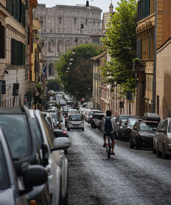 Vehicles on road by buildings in city