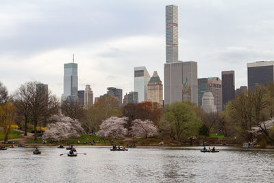 Flowers abound in central park as people enjoy the lake on row boats