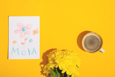 Close-up of yellow and coffee cup on table