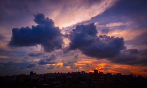 Buildings against cloudy sky at sunset