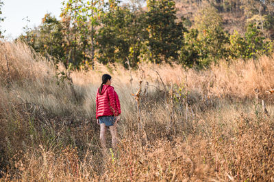 Rear view of woman walking on field