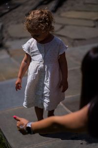 Rear view of mother and girl holding umbrella