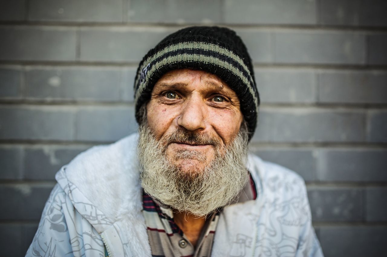 facial hair, beard, portrait, one person, adult, clothing, headshot, real people, males, looking at camera, men, front view, wall - building feature, senior adult, hat, knit hat, lifestyles, mature adult, mature men, warm clothing, human face, mustache