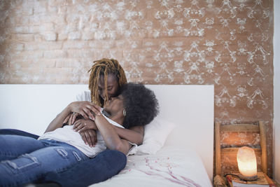 Lesbian couple embracing on bed