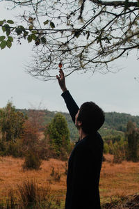 Man touching leaf on branch