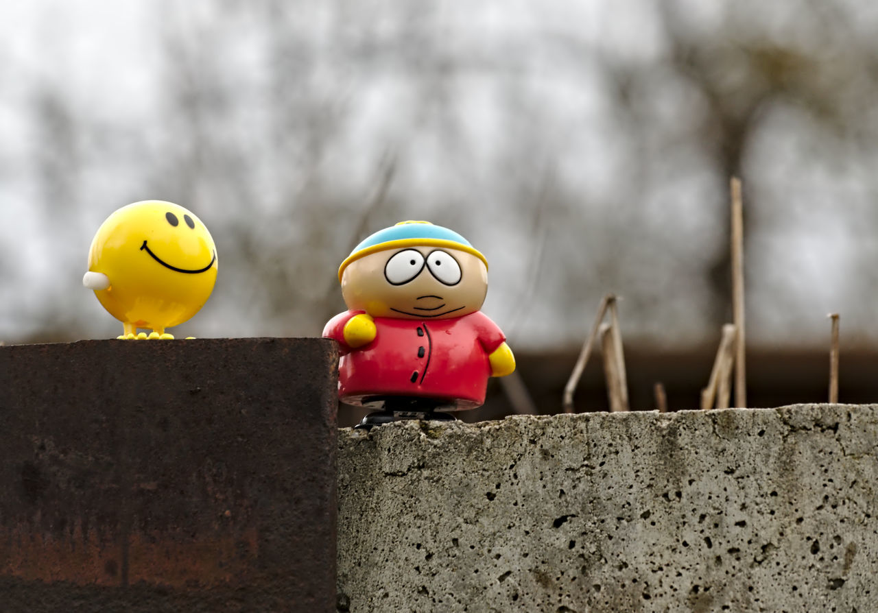 yellow, focus on foreground, toy, close-up, transportation, day, multi colored, sport, outdoors, animal representation, green color, no people, nature, selective focus, road sign, mid-air, communication, warning sign, animals in the wild, sign