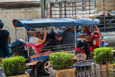 Rear view of people working on street in city