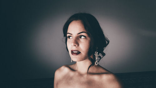 Young woman wearing lipstick and earrings at home