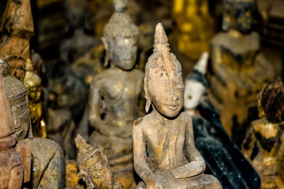 Close-up of old buddha statues for sale in antique store