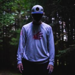 Man wearing cap standing in forest