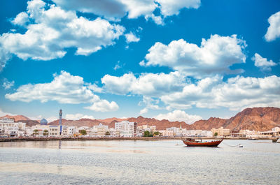 Scenic view of sea by buildings against sky