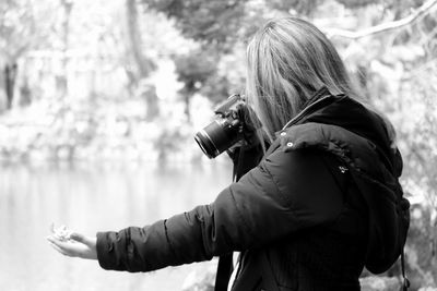 Side view of woman photographing at park