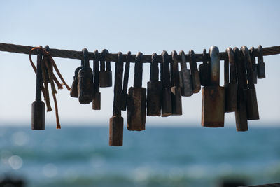 Close-up of padlocks on rope against sky