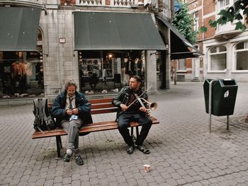 People sitting on street in city
