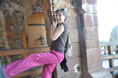 Portrait of woman standing against wall