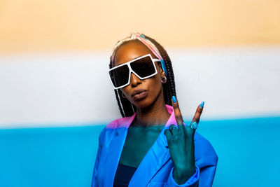 Portrait of woman wearing sunglasses standing against sea