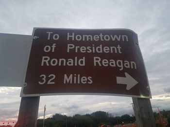 Low angle view of information sign against sky