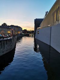 River amidst buildings in city against sky