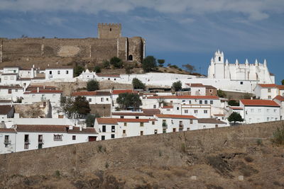 Buildings in town against sky