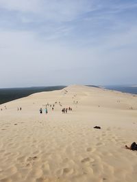 Group of people on beach against sky