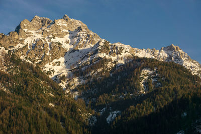 Low angle view of snowcapped mountains against sky